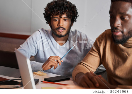 Group of friends using laptop in coworking while discussing their work 86245963