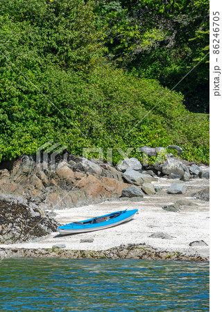 Blue lightweight canoe boat on a shore of ocean bay on sunny day 86246705