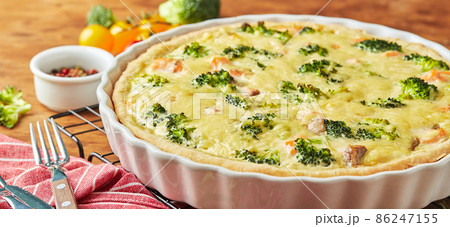 Homemade quiche with red fish, salmon, broccoli and cheese on wooden background Homemade quiche with red fish, salmon, broccoli and cheese on wooden background 86247155