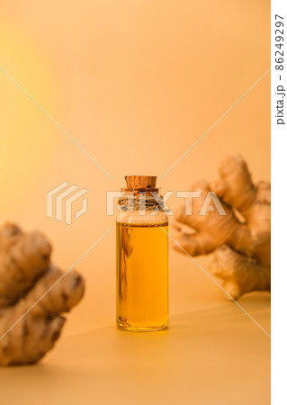 Glass bottle of essential ginger oil, ginger root on beige background. Healthy food eating concept. Zingiber officinale Essential oil. Natural cosmetics ingredients for skincare, body and hair care 86249297