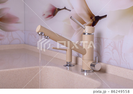 Sand-colored kitchen faucet from which cold water flows Sand-colored kitchen faucet from which cold water flows 86249558