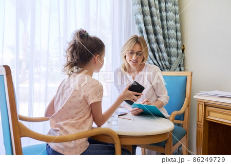 Woman teacher, therapist, social worker talking to preteen girl in office. Woman teacher, therapist, social worker talking to preteen girl in office. 86249729