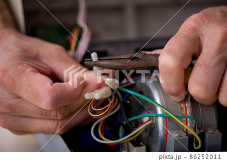 Old repairman repairing air-conditioner at workshop Old repairman repairing air-conditioner at workshop 86252011