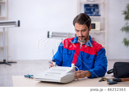 Young male repairman repairing heater Young male repairman repairing heater 86252363