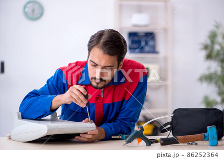Young male repairman repairing heater 86252364