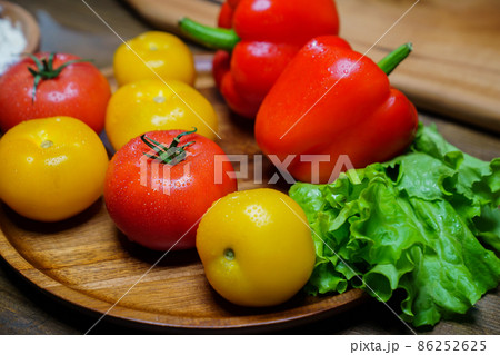 lettuce, yellow and red tomatoes and bell pepper with water drops. cucumbers. lettuce, yellow and red tomatoes and bell pepper with water drops. cucumbers. 86252625