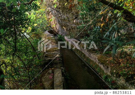 concrete irrigation canal under the rock in a mountainous area concrete irrigation canal under the rock in a mountainous area 86253811