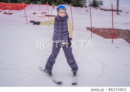 Woman learning to ski. Young woman skiing on a snowy road in the mountains 86254601