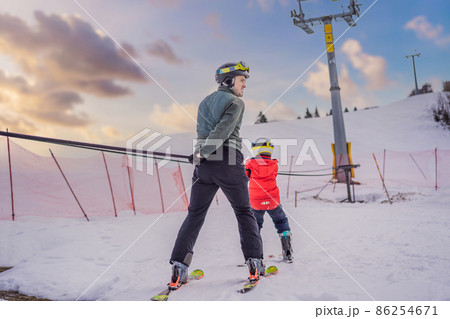 Instructor teaches boy skier to use on ski lift 86254671