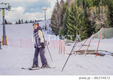 Woman learning to ski. Young woman skiing on a snowy road in the mountains Woman learning to ski. Young woman skiing on a snowy road in the mountains 86254672