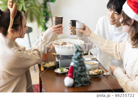 部屋でクリスマス会をする若い男女 部屋でクリスマス会をする若い男女 86255722