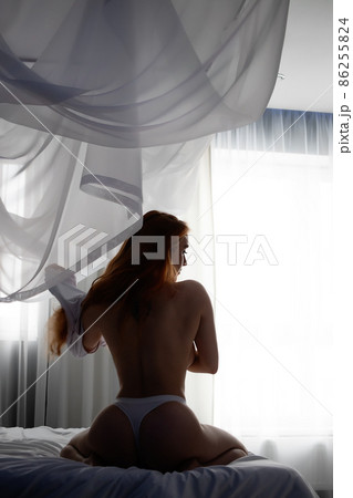 Sensual woman undressing on bed Sensual woman undressing on bed 86255824