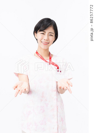 ピンクの花柄スクラブを着た若い女性看護師（白バック） 86257772
