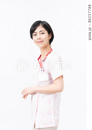 ピンクの花柄スクラブを着た若い女性看護師（白バック） 86257788