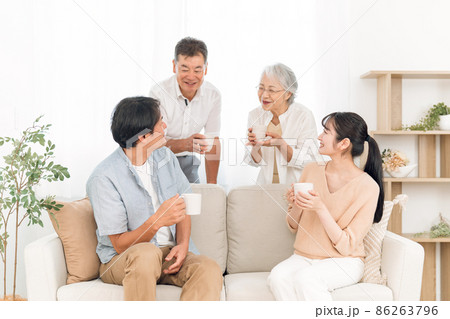 ソファに座って飲み物を飲む家族（話す） 86263796