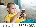 Young boy playing in smartphone. 86264083