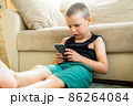 Young boy playing in smartphone. 86264084