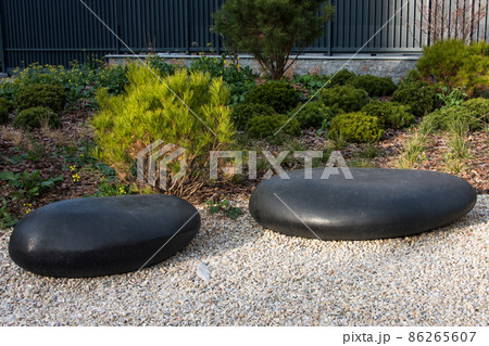 Zen garden dry landscape, or karesansui, japanese rock garden with black stones on white gravel for relaxation and concentration during meditation. Traditional Japanese temple settings Zen garden dry landscape, or karesansui, japanese rock garden with black stones on white gravel for relaxation and concentration during meditation. Traditional Japanese temple settings 86265607