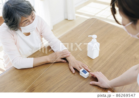介護施設で血中酸素飽和濃度を測ってもらうシニア 86269547