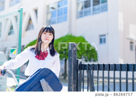 学校の校門から自転車を押して下校する女子高校生 住宅地 市街地 学校の校門から自転車を押して下校する女子高校生 住宅地 市街地 86269757