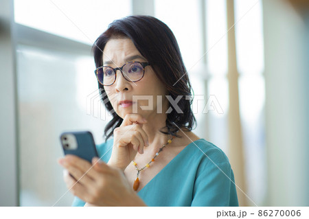 スマホを見るシニア女性 スマホを見るシニア女性 86270006