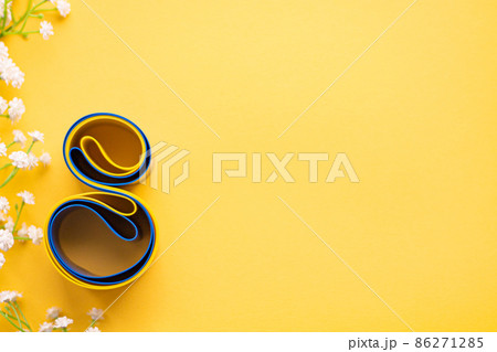 Elastic tape for fitness lies on a yellow background. Eight from a rubber expander for sports. White blumen Elastic tape for fitness lies on a yellow background. Eight from a rubber expander for sports. White blumen 86271285