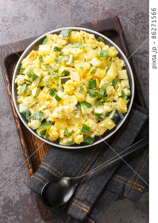 Zarangollo Murciano Stewed Zucchini With Onion and scrambled closeup in the plate. Vertical top view 86271566