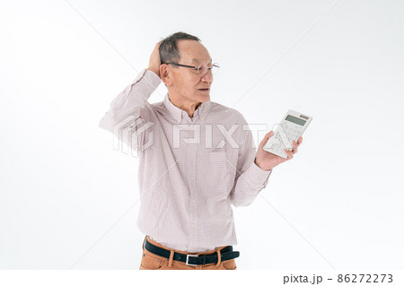 計算機を持つて悩むシニア男性 計算機を持つて悩むシニア男性 86272273
