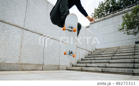 Skateboarder skateboarding outdoors in city 86272311