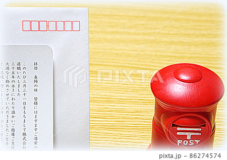 【イラスト風】木目の机に置いた郵便ポスト形の貯金箱と礼文の封筒 86274574