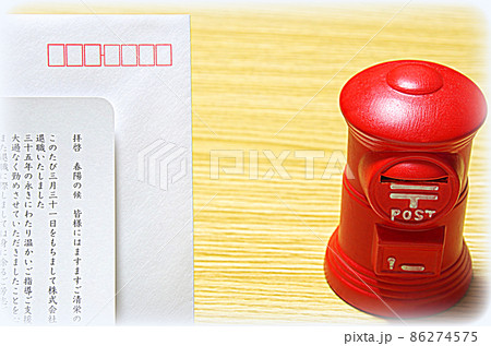 【イラスト風】木目の机に置いた郵便ポスト形の貯金箱と礼文の封筒 86274575