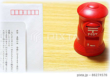 【イラスト風】木目の机に置いた郵便ポスト形の貯金箱と礼文の封筒 86274576