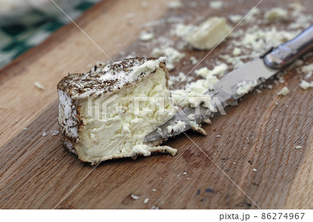 Fresh goat cheese with knife on wooden board Fresh goat cheese with knife on wooden board 86274967