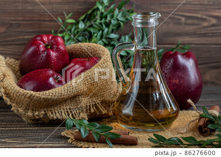 Apple cider vinegar and red apples on a dark, wooden background. Selective focus. fermented product. Healthy food. 86276600