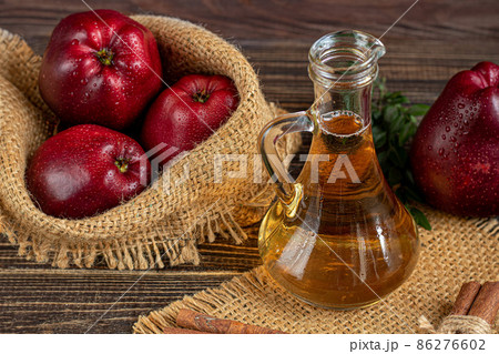 Apple cider vinegar and red apples on a dark, wooden background. Selective focus. fermented product. Healthy food. 86276602