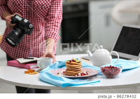 Food blogger taking photo of her breakfast at table, closeup Food blogger taking photo of her breakfast at table, closeup 86278432