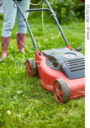 unrecognizable Woman with a lawn mower grass at home garden, gardener woman working 86279711