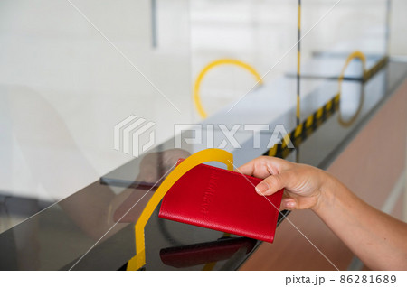 Faceless woman giving her passport at the airport check-in counter. Faceless woman giving her passport at the airport check-in counter. 86281689