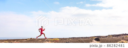 Athlete running man athlete on triathlon run. Hero profile view of runner on hill training hiit workout going uphill. Panoramic landscape crop background 86282481