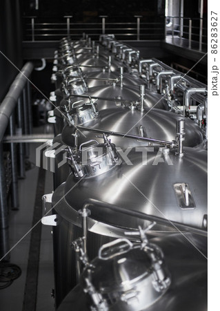 Modern Beer Factory. Steel tanks for beer fermentation and storage. Brewery. Modern beer plant with brewering kettles Modern Beer Factory. Steel tanks for beer fermentation and storage. Brewery. Modern beer plant with brewering kettles 86283627