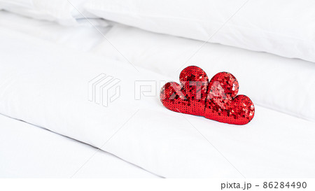 Blurred Romantic interior for Valentine's day with bed. Two red hearts on white. 86284490