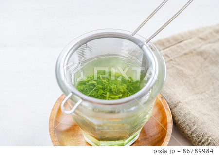 茶こしでグラスに入れる緑茶 86289984