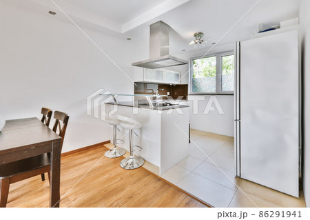 A fascinating kitchen with a mirrored black countertop and beige tiled floor 86291941