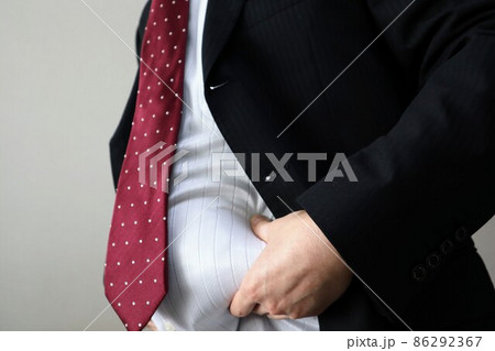 お腹の脂肪をつまむ会社員男性 86292367