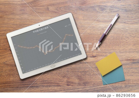 タブレット端末に映る日本の平均給与額の推移グラフ 86293656
