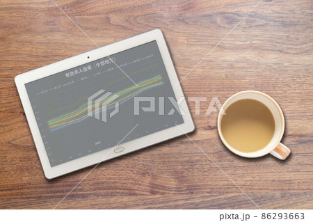 中部地方の有効求人倍率が映るタブレットとコーヒーカップ 86293663