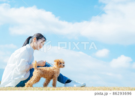 愛犬と遊ぶ女性(芝生・座る) 愛犬と遊ぶ女性(芝生・座る) 86293696