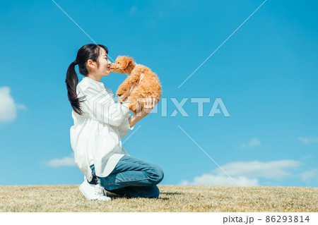 愛犬と遊ぶ女性（キス） 86293814