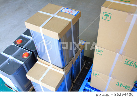 輸送時の作業性の為、PPバンドが掛けられた段ボールケースとスチールの一斗缶 86294406