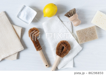 Eco friendly bamboo dish brushes and lemon with baking soda for cleaning top view. Eco friendly bamboo dish brushes and lemon with baking soda for cleaning top view. 86296850